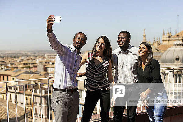 Glückliche multiethnische Kollegen machen in der Pause ein Selfie auf dem Dach des Büros