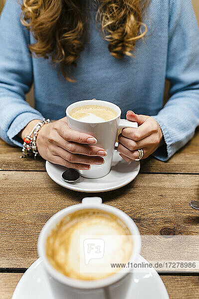 Frau trinkt Kaffee am Tisch