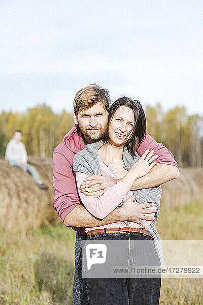 Paar umarmt auf einem Feld an einem sonnigen Tag