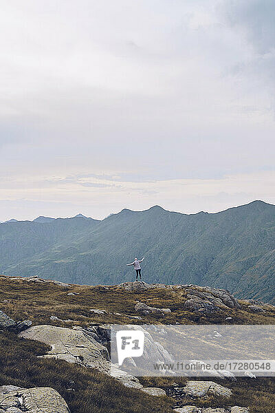 Junge Frau bewundert die Aussicht  während sie auf einem Berg in der Nähe von Ibones of Anayet steht