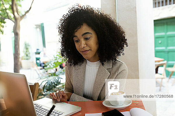Unternehmerin  die im Café sitzend am Laptop arbeitet