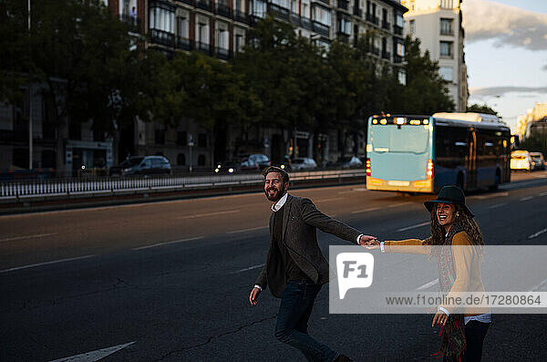 Paar hält sich beim Überqueren der Straße in der Stadt an den Händen
