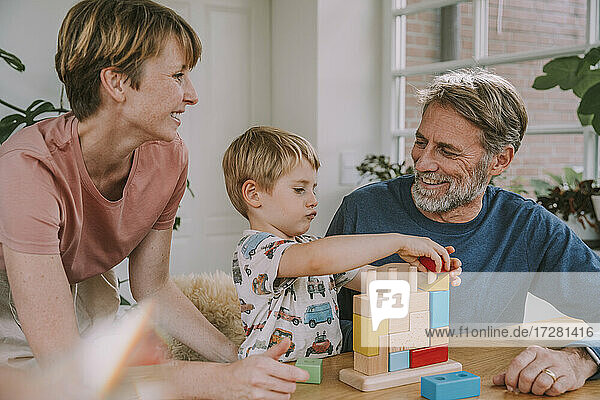 Mutter und Vater spielen mit Sohn Spielzeug Block Puzzle zu Hause