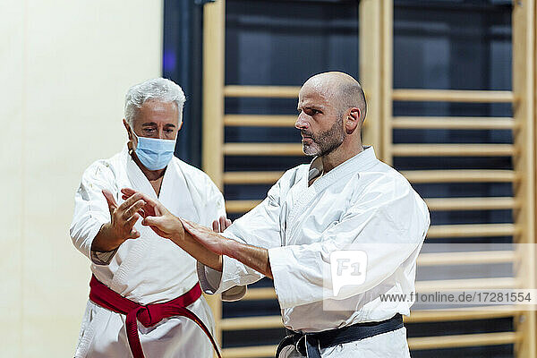 Ausbilder unterrichtet einen männlichen Schüler in Karate