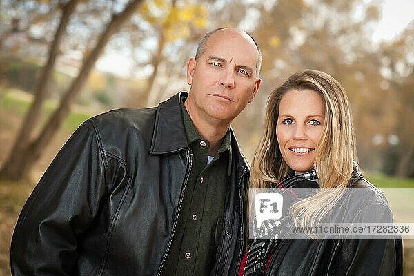 Glückliches  attraktives Paar im Park mit Lederjacken