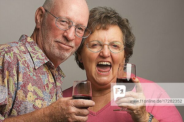 Happy senior couple toasting wine glasses