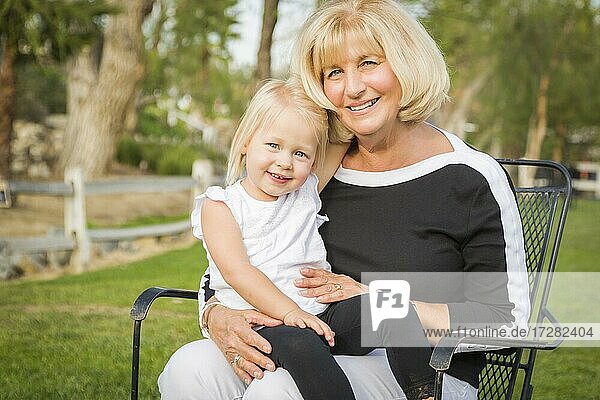 Zärtliche Großmutter und Enkelin spielen draußen im Park