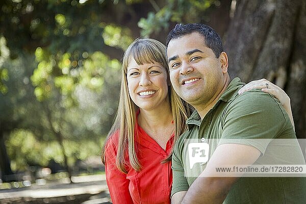 Happy attractive mixed-race couple portrait at the park