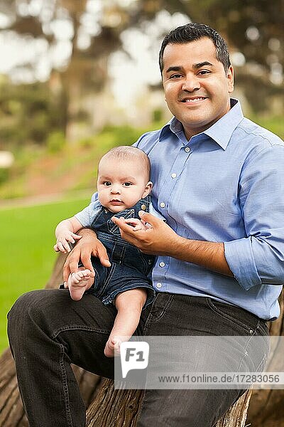 Handsome hispanic father and son posing for A portrait in the park