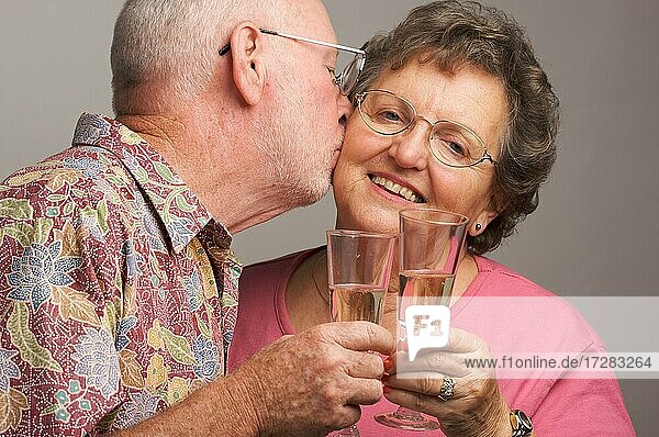 Happy senior couple toasting with champagne glasses
