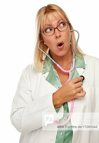 Attraktive Ärztin oder Krankenschwester überprüft ihr eigenes Herz vor einem weißen Hintergrund