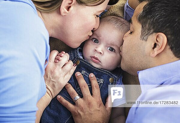 mixed-race parent kissing their son together