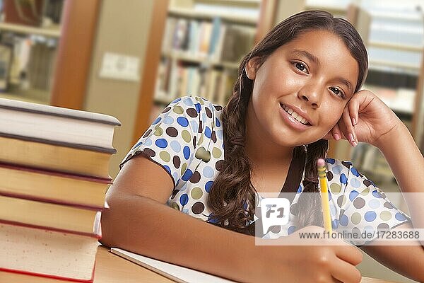 Glückliche hispanische Mädchen Student mit Bleistift und Bücher studieren in der Bibliothek