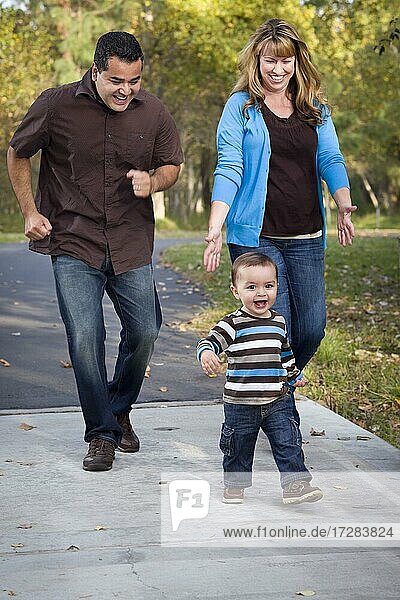Happy young mixed-race ethnic family walking in the park