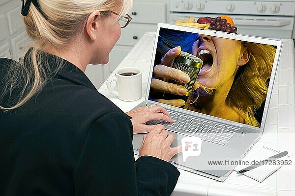 Frau in der Küche mit Laptop für Musik und Unterhaltung. Bildschirm kann leicht für Ihre eigene Nachricht oder Bild verwendet werden