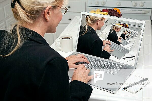 Frau in Küche mit Laptop. Bildschirm kann leicht für Ihre eigene Nachricht oder Bild verwendet werden. Bild auf dem Bildschirm ist auch mein Copyright