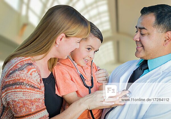Glückliche gemischtrassige Junge  Mutter und hispanischen Arzt Spaß mit Stethoskop im Krankenhaus Büros haben