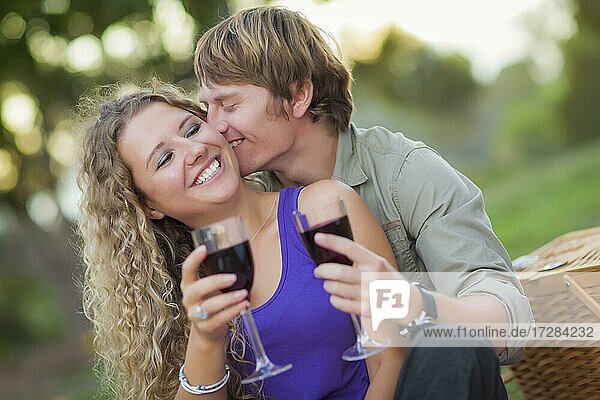 An attractive couple enjoying A glass of wine in the park together