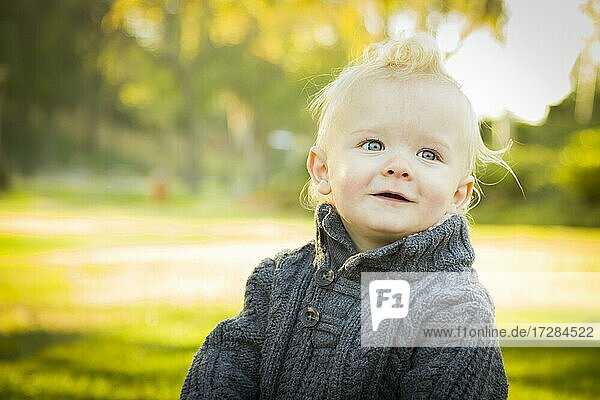 Adorable little blonde baby boy outdoors at the park