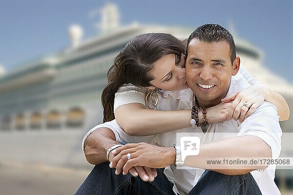 Junge glückliche hispanische Paar umarmt auf dem Dock vor einem Kreuzfahrtschiff