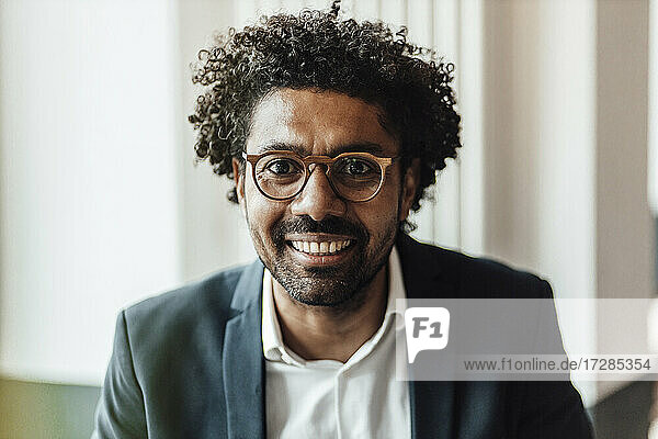 Smiling mature businessman with curly hair wearing eyeglasses