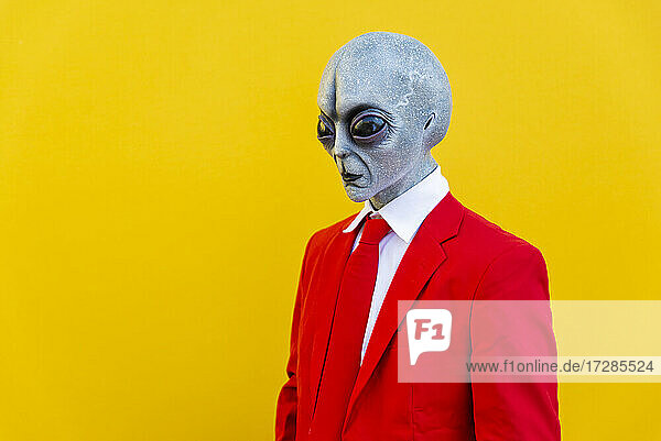 Porträt eines Mannes in Alien-Kostüm und leuchtend rotem Anzug