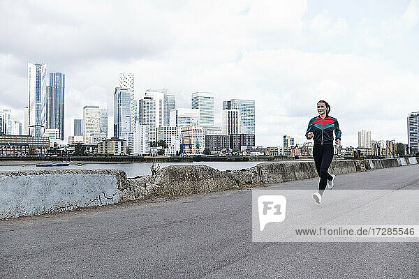 Weibliche Athletin läuft auf der Promenade in der Stadt
