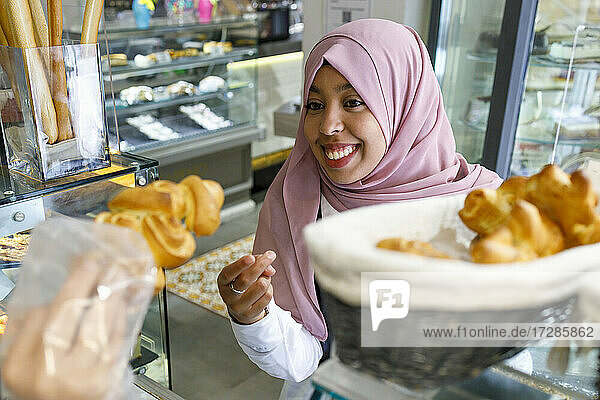 Happy woman buying pastry in bakery