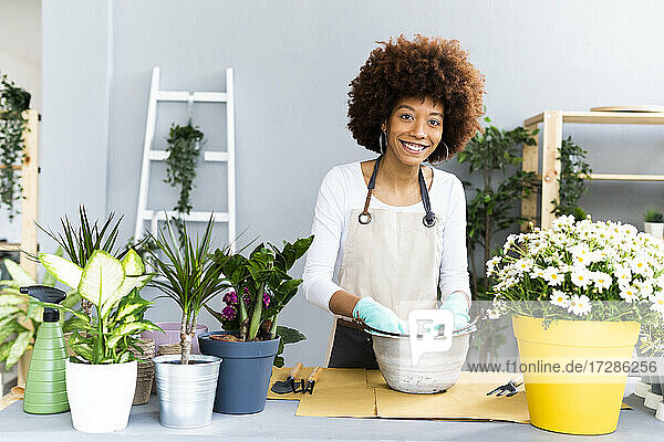 Weibliche Ladenbesitzerin lächelt bei der Arbeit im Blumenladen
