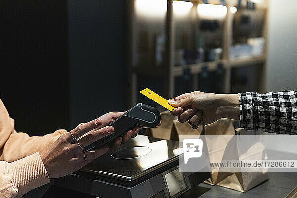 Frau  die in einem Geschäft mit Kreditkarte bezahlt