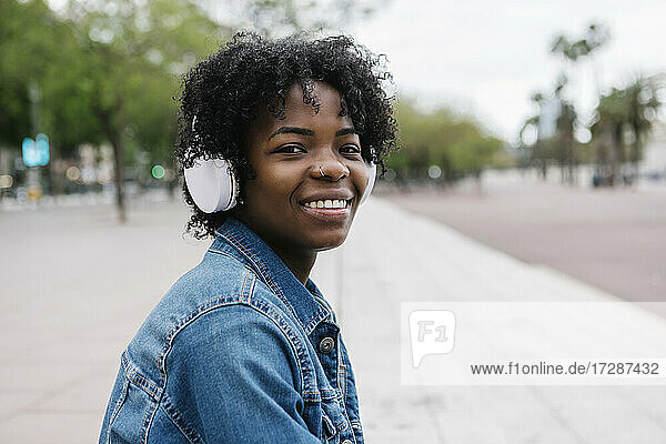 Glückliche Frau mit Kopfhörern beim Musikhören