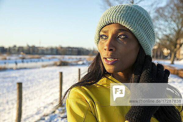 Beautiful mature woman wearing blue knit hat while looking away