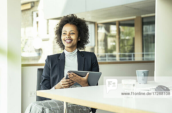 Lächelnde Unternehmerin mit digitalem Tablet im Büro