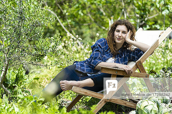 Frau entspannt sich auf einem Stuhl im Garten