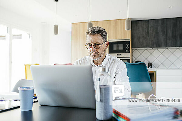 Seriöser Geschäftsmann arbeitet am Laptop im Home Office
