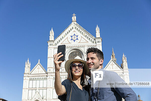 Touristisches Paar macht ein Selfie mit dem Smartphone vor der Basilika Santa Croce  Florenz  Italien