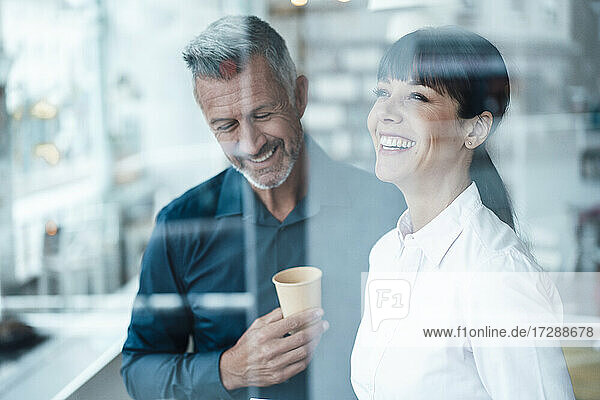 Lächelnde männliche und weibliche Unternehmer  die in einem Café stehen