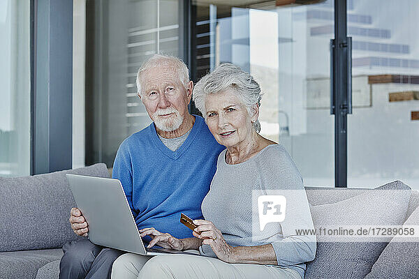 Älteres Paar benutzt Laptop beim Online-Shopping zu Hause