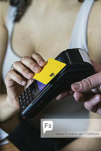 Junge Frau zahlt im Restaurant mit Kreditkarte