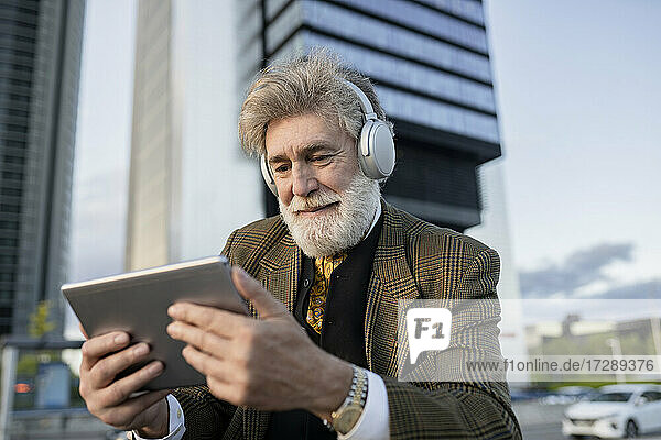 Geschäftsmann sieht sich in der Stadt ein Video auf einem digitalen Tablet an