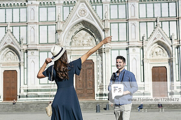 Weiblicher Tourist gestikuliert  während er mit einem Mann auf der Piazza Di Santa Croce  Florenz  Italien  steht