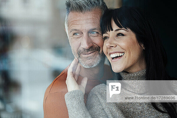 Smiling woman leaning on man at cafe