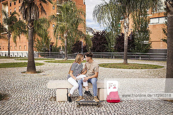 Romantisches Paar sitzt auf einer Bank im Park