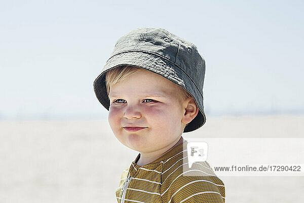 Smiling cute boy wearing hat looking away