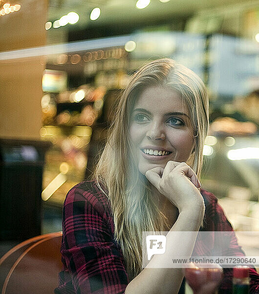 Blonde Frau schaut weg  während sie im Café sitzt