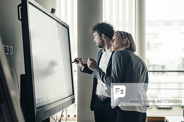 Professionelles Team bei der Arbeit an einer Projektionsfläche im Büro