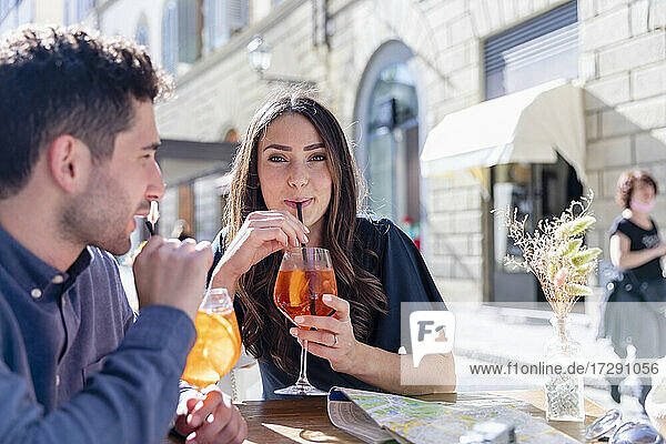 Tourists drinking aperitif at sidewalk cafe