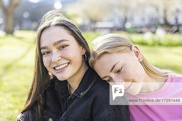 Young woman with head on shoulder of female friend at park
