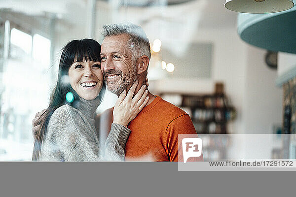 Lächelnde Frau steht neben einem Mann in einem Cafe