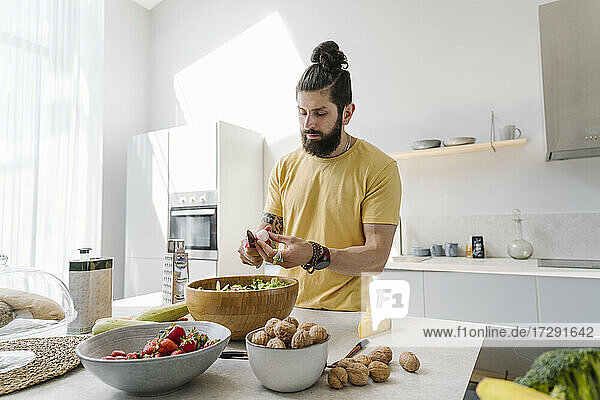 Man with beard cutting vegetable in kitchen